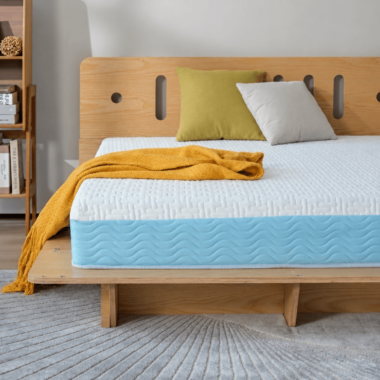 Colchón blanco y celeste sobre cama de madera, vista de detalle
